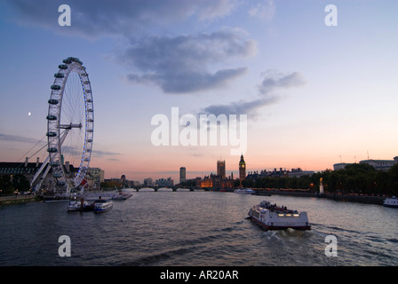 In orizzontale ampia angolazione del fiume Tamigi al tramonto con il London Eye Millenium ruota" e le case del Parlamento. Foto Stock