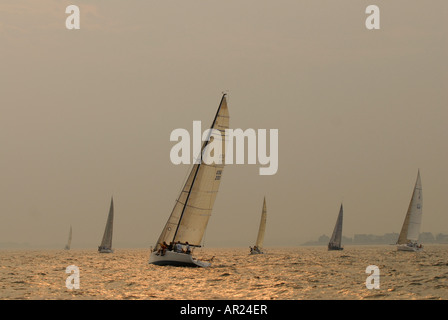 Barche a vela in una regata gara in Old Saybrook Connecticut USA con il tramonto del sole Foto Stock