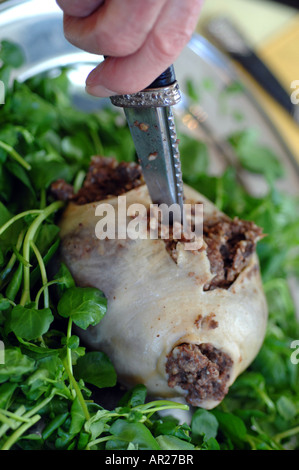 Il taglio del haggis con un Sgian Dubh sulla notte di Burns, Scozia Foto Stock