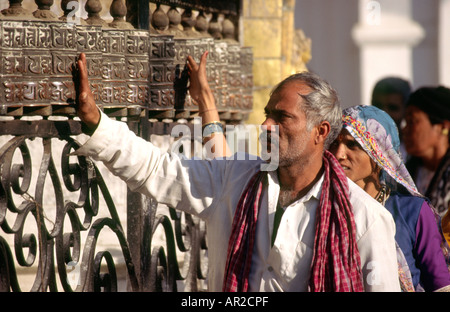 Il Nepal Kathmandu Buddismo Tempio Swayambunath uomo con ruote della preghiera Foto Stock