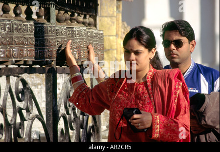 Il Nepal Kathmandu Buddismo Swayambunath tempio indù l uomo e la donna utilizzando la preghiera buddista ruote Foto Stock