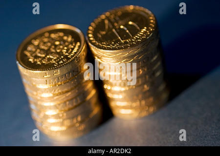 Due pile di British pound monete su sfondo blu Foto Stock