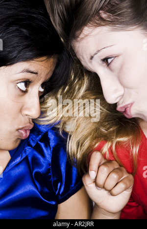 Due amiche, una luce-scuoiate e una di carnagione scura donna busbana francese e guardando profondamente nei loro occhi Foto Stock