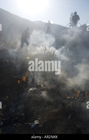 Residenti estinguere un incendio in una discarica durante gli incendi boschivi in estate 2007, Grecia, Peloponnes, Mani Skoutari Foto Stock