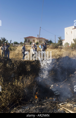 Residenti estinguere un incendio in una discarica durante gli incendi boschivi in estate 2007, Grecia, Peloponnes, Mani Skoutari Foto Stock