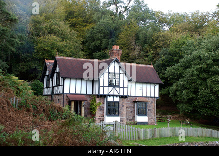 Cottage in stile vittoriano nel bosco impostazione, Cornwall Foto Stock