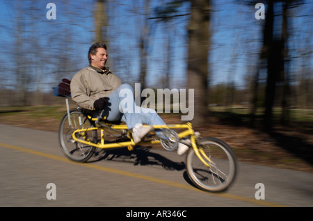 Uomo che cavalca Recumbent bicicletta giù per la collina Foto Stock