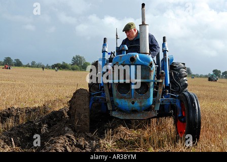 Agricoltore sul trattore vintage, aratura corrispondono Foto Stock