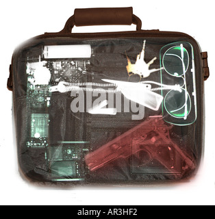 Simulazione di controlli di sicurezza in aeroporto a raggi X che mostra una valigetta contenente una Smith e Wesson 9mm pistola Foto Stock