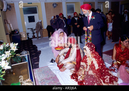 La religione sikh Wedding Brides madre sposo di alimentazione nel centro di Gurdwara Shepherds Bush London Inghilterra England Foto Stock