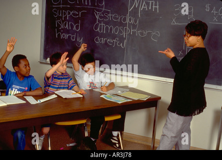 Interracial classe e insegnante età 25 e 9 in dopo la scuola programma di lettura. St Paul Minnesota USA Foto Stock