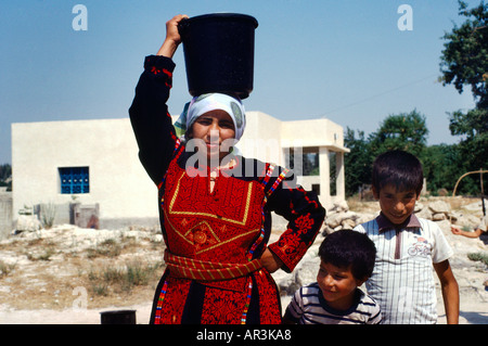 In Cisgiordania Israele Christian Aid donna portando acqua sulla testa Foto Stock