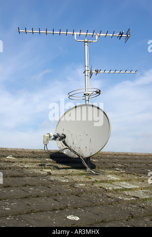 Abitazione domestica vista sul tetto della selezione di antenne montate sul polo sporgente dal tetto camino n. Foto Stock