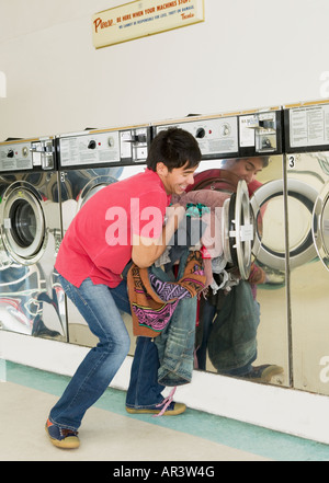 Uomo asiatico in lavanderia a gettoni Foto Stock