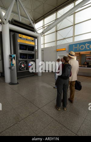 Passeggeri (padre figlia) all'interno di l'aeroporto di Stansted guardando i tempi - le due principali persone sono modello rilasciato. Foto Stock