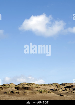 Cielo blu chiaro con soffici nuvole bianche oltre le dune di sabbia Foto Stock