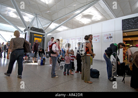 Passeggeri all'interno l'aeroporto di Stansted a camminare verso la sicurezza Foto Stock