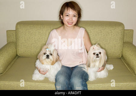 Donna sul divano con cani pekinese Foto Stock