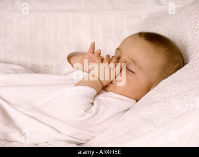 Sleeping Baby girl succhiare il suo pollice Foto Stock