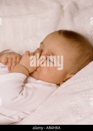 Sleeping Baby girl succhiare il suo pollice Foto Stock