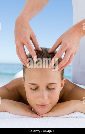 Giovane donna avente testa massaggiato Foto Stock