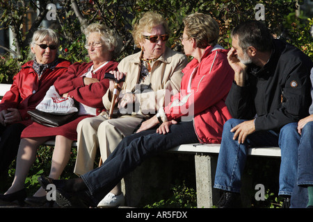 Gli anziani seduti su una panchina nel parco Foto Stock