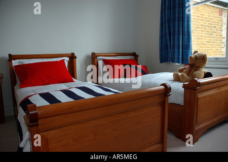 Cuscini rossi sui tradizionali letti letti in legno nella moderna camera da letto grigio Foto Stock