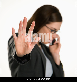 Caucasian metà adulto professional business donna parlando al cellulare tenendo la mano al visualizzatore di arresto Foto Stock