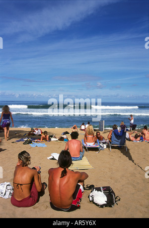 Una folla seduto sulla spiaggia a guardare la parte del triple crown surf in concorrenza Haleiwa sulla North Shore di Oahu, Hawaii Foto Stock