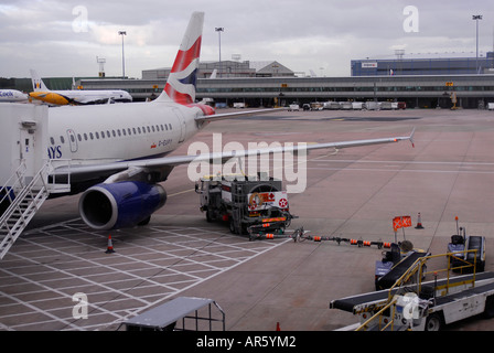 Un British Airways aeromobile è rifornito da un combustibile bowser carrello a terra all'Aeroporto Internazionale di Manchester Foto Stock