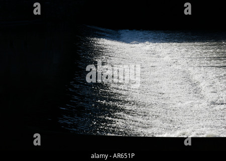 Bianco e nero acqua correre su uno stramazzo sul fiume Lot a Cahors in Francia Foto Stock