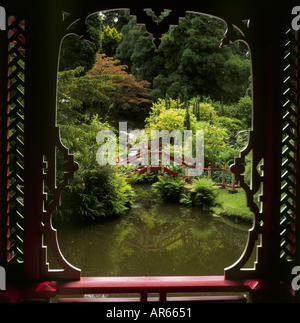 Guardando attraverso una finestra nella Cina Tempio per un ponte stagno in Biddulph Grange Giardino Staffordshire Foto Stock