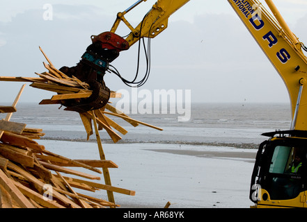 Eliminazione di residui di legno che è stato lavato fino a Worthing beach dal principe di ghiaccio Foto Stock