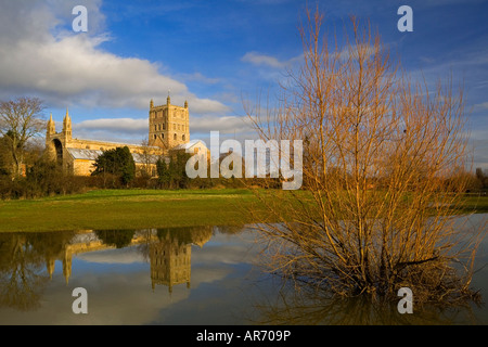 Tewkesbury Abbey Santa Maria Vergine Chiesa Gloucestershire England Regno Unito con torre riflessa nell'acqua in primo piano Foto Stock