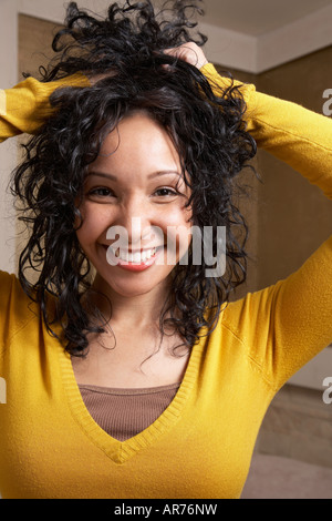 Donna ispanica giocando con i capelli Foto Stock