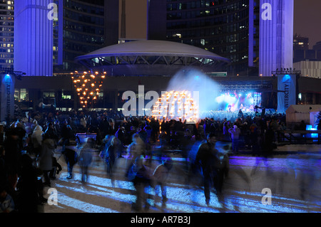 Pattinatori sfocata a Toronto City Hall durante Wintercity notti di fuoco con il Weakerthans mostrano Nathan Philips Square in inverno Foto Stock