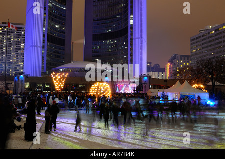 I pattinatori sulla pista di pattinaggio su ghiaccio a Toronto city hall durante wintercity notti di fuoco e weakerthans musicisti rock spettacolo fase Foto Stock