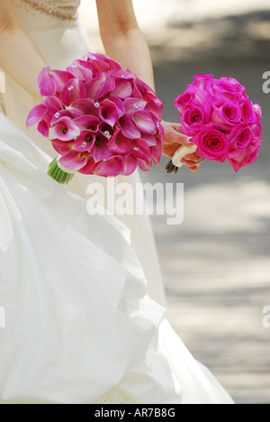 Sposa e damigella holding mazzi di fiori di colore rosa Foto Stock