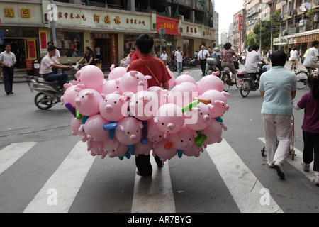 Un venditore ambulante a Shanghai in Cina la vendita di palloncini gonfiabili a forma di suini. Foto Stock