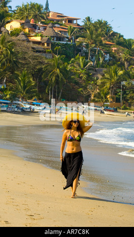 Messico Nayarit villaggio di Sayulita vicino a Puerto Vallarta sull'Oceano Pacifico donna nel cappello giallo godendo una giornata in spiaggia Foto Stock