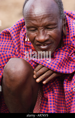 Ritratto di uomo Masai indossando trraditional mantello e decorazioni messa a fuoco con bastoni Foto Stock