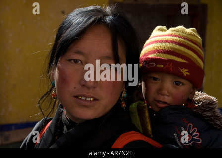 Una foto in orizzontale dei tibetani lady pellegrino tenendo il suo bambino sulla scalinata del Palazzo del Potala giorno di nuovi anni, Lhasa in Tibet, in Cina. Foto Stock