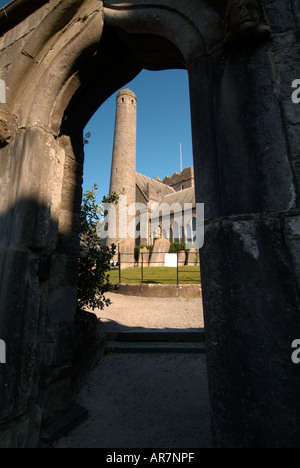 Kilkenny, vista verticale attraverso un'arcata ornata di Canices cattedrale e la torre rotonda sotto un cielo blu, Kilkenny, Irlanda Foto Stock