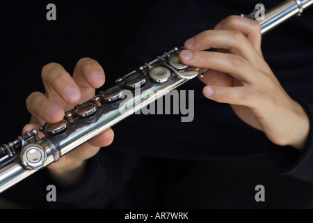 Flauto le mani del giocatore in uno sfondo nero Foto Stock