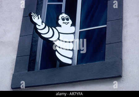 Bibendum, la Michelin, l'uomo, salutando dalla finestra sopra la Michelin shop, Place de la Victoire, Clermont-Ferrand, Auvergne, Francia Foto Stock