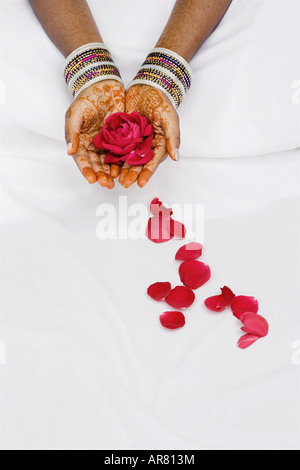 Ragazza indiana con henné mani red rose e petali Foto Stock