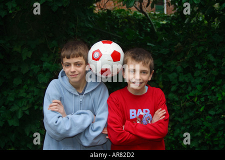 Due ragazzi di calcio di bilanciamento, con le braccia incrociate Foto Stock