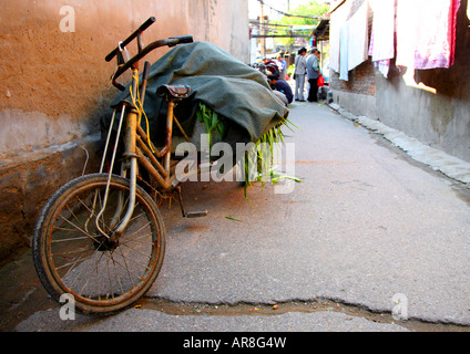 Vecchia bicicletta parcheggiata in un "hutong" Lane, a Pechino. Foto Stock