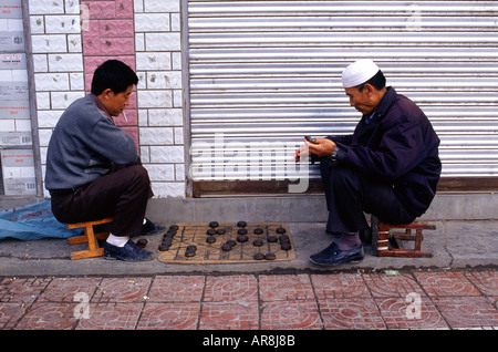 Uomini cinesi che giocano Xiangqi anche chiamato scacchi cinesi che è un gioco di strategia da tavolo in un marciapiede nella città di Tongren nella provincia di Guizhou Cina Foto Stock