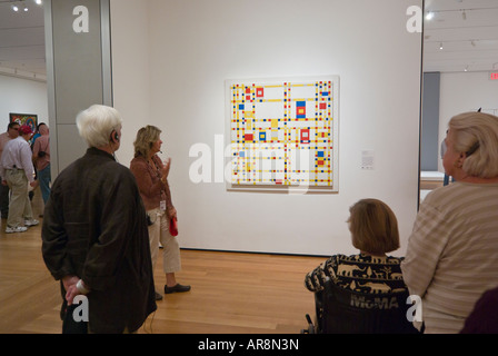 Guida e spettatori di fronte dipinto di Mondrian, Broadway Boogie Woogie, il Museo di Arte Moderna di New York Foto Stock